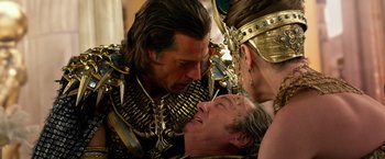 Movie still from “Gods of Egypt” (2016), directed by Alex Proyas – A man in a gold and black suit is kissing a woman in a gold and black suit; Close Up shot, Over the shoulder angle