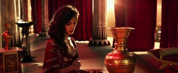 Movie still from “Gods of Egypt” (2016), directed by Alex Proyas – A beautiful woman in a red and gold dress; Medium shot, High angle