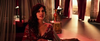 Movie still from “Gods of Egypt” (2016), directed by Alex Proyas – A woman in a red dress sitting in front of a lamp; Close Up shot, Over the shoulder angle