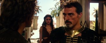 Movie still from “Gods of Egypt” (2016), directed by Alex Proyas – A man and a woman standing next to each other in front of palm trees; Close Up shot, Over the shoulder angle