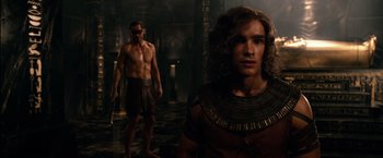 Movie still from “Gods of Egypt” (2016), directed by Alex Proyas – A man and a woman standing next to each other in a room; Medium shot, Over the shoulder angle