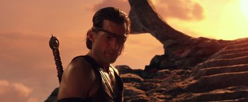Movie still from “Gods of Egypt” (2016), directed by Alex Proyas – A person with a rock in the background; Medium shot, Over the shoulder angle