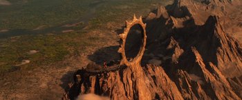 Movie still from “Gods of Egypt” (2016), directed by Alex Proyas – A man standing on top of a mountain looking at a ring of fire; Extreme Wide shot, High angle