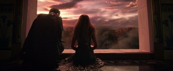 Movie still from “Gods of Egypt” (2016), directed by Alex Proyas – A woman sitting on a window ledge looking out at a sunset; Medium shot, High angle
