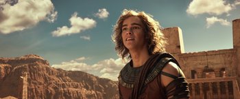 Movie still from “Gods of Egypt” (2016), directed by Alex Proyas – A young man in a costume standing on top of a mountain; Close Up shot, Low angle