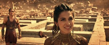 Movie still from “Gods of Egypt” (2016), directed by Alex Proyas – A woman in a brown dress and gold jewelry; Close Up shot, Over the shoulder angle