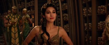 Movie still from “Gods of Egypt” (2016), directed by Alex Proyas – A beautiful woman in a gold dress posing for a picture; Close Up shot, Over the shoulder angle