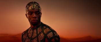 Movie still from “Gods of Egypt” (2016), directed by Alex Proyas – A man wearing a gold crown and a green and gold outfit; Close Up shot, Low angle