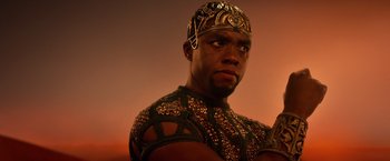 Movie still from “Gods of Egypt” (2016), directed by Alex Proyas – A man wearing a gold and black outfit and a gold helmet; Close Up shot, Low angle
