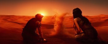Movie still from “Gods of Egypt” (2016), directed by Alex Proyas – A man and a woman standing in front of an erupting volcano; Wide shot, High angle