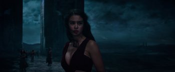 Movie still from “Gods of Egypt” (2016), directed by Alex Proyas – A beautiful woman in a red dress standing in front of a body of water at night; Medium shot, Low angle