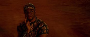 Movie still from “Gods of Egypt” (2016), directed by Alex Proyas – A man wearing a hat and a shirt; Close Up shot, Over the shoulder angle