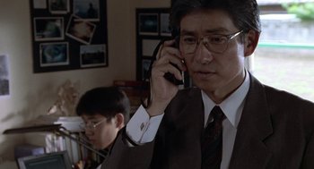 Movie still from “Godzilla vs. Destoroyah” (1995), directed by Ishirô Honda – A man in a suit and tie talking on a cell phone; Close Up shot, Over the shoulder angle