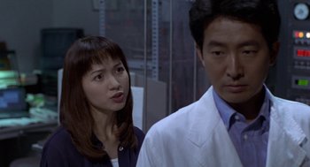Movie still from “Godzilla vs. Destoroyah” (1995), directed by Ishirô Honda – A man and a woman standing next to each other; Close Up shot, Over the shoulder angle