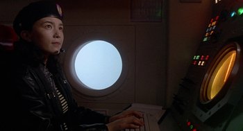Movie still from “Godzilla vs. Destoroyah” (1995), directed by Ishirô Honda – A person sitting in front of a computer keyboard; Medium shot, Low angle