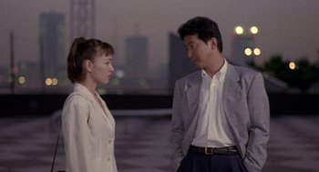 Movie still from “Godzilla vs. Destoroyah” (1995), directed by Ishirô Honda – A man and a woman standing next to each other in front of a body of water; Medium shot, Over the shoulder angle
