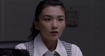 Movie still from “Godzilla vs. Destoroyah” (1995), directed by Ishirô Honda – A young woman wearing a checkered shirt and tie; Close Up shot, Over the shoulder angle
