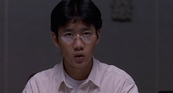 Movie still from “Godzilla vs. Destoroyah” (1995), directed by Ishirô Honda – A young man wearing glasses looking at the camera; Close Up shot, High angle
