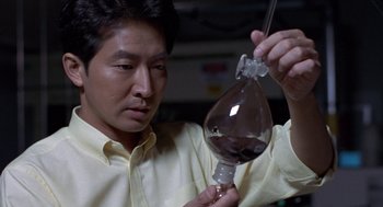 Movie still from “Godzilla vs. Destoroyah” (1995), directed by Ishirô Honda – A man holding a bottle of liquid in his hand; Close Up shot, High angle