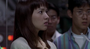 Movie still from “Godzilla vs. Destoroyah” (1995), directed by Ishirô Honda – A young woman looking to her left while standing next to a man; Close Up shot, Over the shoulder angle