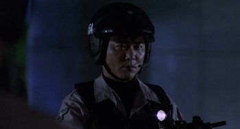 Movie still from “Godzilla vs. Destoroyah” (1995), directed by Ishirô Honda – A police officer wearing a helmet with a light on his head; Close Up shot, Low angle