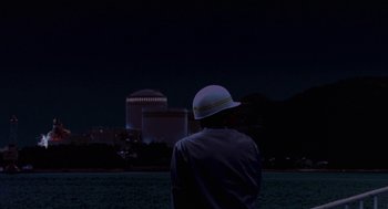 Movie still from “Godzilla vs. Destoroyah” (1995), directed by Ishirô Honda – A man wearing a white hat looking at a nuclear power plant; Extreme Wide shot, Low angle