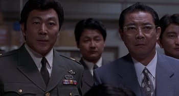 Movie still from “Godzilla vs. Destoroyah” (1995), directed by Ishirô Honda – A group of men standing next to each other in a room; Close Up shot, Low angle