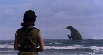 Movie still from “Godzilla vs. Destoroyah” (1995), directed by Ishirô Honda – A woman standing in the ocean looking at a giant godzilla; Extreme Wide shot, Over the shoulder angle