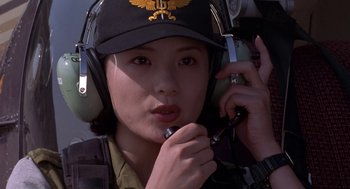 Movie still from “Godzilla vs. Destoroyah” (1995), directed by Ishirô Honda – A woman wearing a hat and holding a cell phone to her ear while sitting in an airplane; Close Up shot, Low angle