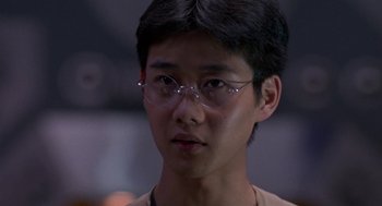 Movie still from “Godzilla vs. Destoroyah” (1995), directed by Ishirô Honda – A young man wearing glasses looking at the camera; Close Up shot, Over the shoulder angle