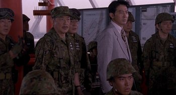 Movie still from “Godzilla vs. Destoroyah” (1995), directed by Ishirô Honda – A group of men standing next to each other in uniform; Medium shot, Over the shoulder angle