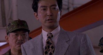 Movie still from “Godzilla vs. Destoroyah” (1995), directed by Ishirô Honda – A person wearing a suit and a tie; Close Up shot, Low angle