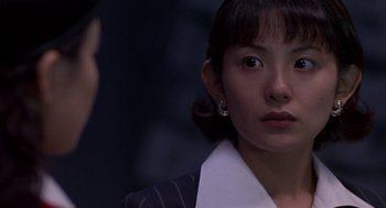 Movie still from “Godzilla vs. Destoroyah” (1995), directed by Ishirô Honda – A young woman with her eyes wide open looking at the camera; Close Up shot, Over the shoulder angle