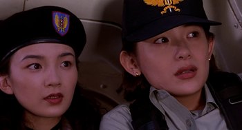 Movie still from “Godzilla vs. Destoroyah” (1995), directed by Ishirô Honda – Two young women in military uniforms sitting next to each other in an airplane; Close Up shot, Low angle