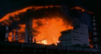Movie still from “Godzilla vs. Destoroyah” (1995), directed by Ishirô Honda – A large fire burning in a factory at night time; Extreme Wide shot, Low angle