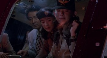 Movie still from “Godzilla vs. Destoroyah” (1995), directed by Ishirô Honda – A group of people sitting next to each other on a train; Medium shot, Low angle