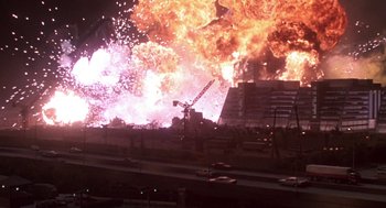 Movie still from “Godzilla vs. Destoroyah” (1995), directed by Ishirô Honda – An explosion is seen in the background of a construction site; Extreme Wide shot, High angle