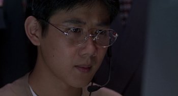 Movie still from “Godzilla vs. Destoroyah” (1995), directed by Ishirô Honda – A man wearing glasses and a headset looking to his left; Close Up shot, Low angle