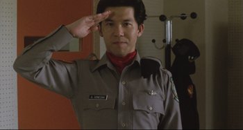 Movie still from “Godzilla vs. Mechagodzilla II” (1993), directed by Kazuki Ômori – A man saluting in front of a mirror wearing a uniform; Close Up shot, Low angle