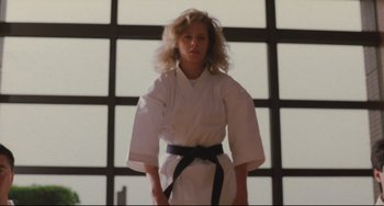 Movie still from “Godzilla vs. Mechagodzilla II” (1993), directed by Kazuki Ômori – A woman in a karate outfit standing in front of a window; Medium shot, Low angle