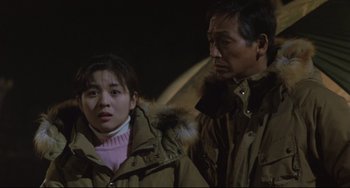 Movie still from “Godzilla vs. Mechagodzilla II” (1993), directed by Kazuki Ômori – A man and a woman standing next to each other; Medium shot, Low angle