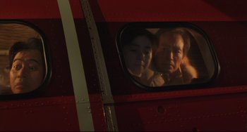 Movie still from “Godzilla vs. Mechagodzilla II” (1993), directed by Kazuki Ômori – A man and a woman looking out of a plane window; Medium shot, Low angle