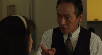 Movie still from “Godzilla vs. Mechagodzilla II” (1993), directed by Kazuki Ômori – An older man wearing a vest talking to a young woman; Close Up shot, Over the shoulder angle