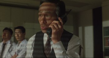 Movie still from “Godzilla vs. Mechagodzilla II” (1993), directed by Kazuki Ômori – A man talking on a cell phone while wearing a vest; Close Up shot, Low angle