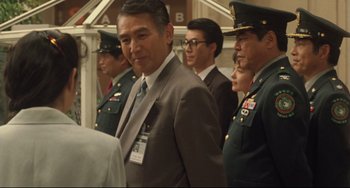 Movie still from “Godzilla vs. Mechagodzilla II” (1993), directed by Kazuki Ômori – A group of men in military uniforms standing next to each other; Medium shot, Over the shoulder angle