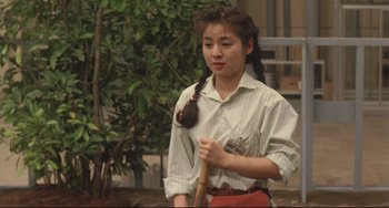 Movie still from “Godzilla vs. Mechagodzilla II” (1993), directed by Kazuki Ômori – A young woman holding a baseball bat in her hands; Medium shot, High angle
