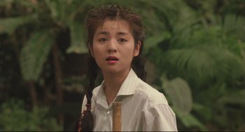 Movie still from “Godzilla vs. Mechagodzilla II” (1993), directed by Kazuki Ômori – A young woman holding a knife in her hand; Close Up shot, Over the shoulder angle
