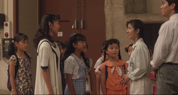 Movie still from “Godzilla vs. Mechagodzilla II” (1993), directed by Kazuki Ômori – A group of young people standing next to each other; Medium shot, Over the shoulder angle