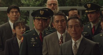 Movie still from “Godzilla vs. Mechagodzilla II” (1993), directed by Kazuki Ômori – A group of men in suits and ties standing next to each other; Medium shot, High angle