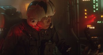 Movie still from “Godzilla vs. Mechagodzilla II” (1993), directed by Kazuki Ômori – A man wearing a helmet looking at his cell phone; Medium shot, Low angle